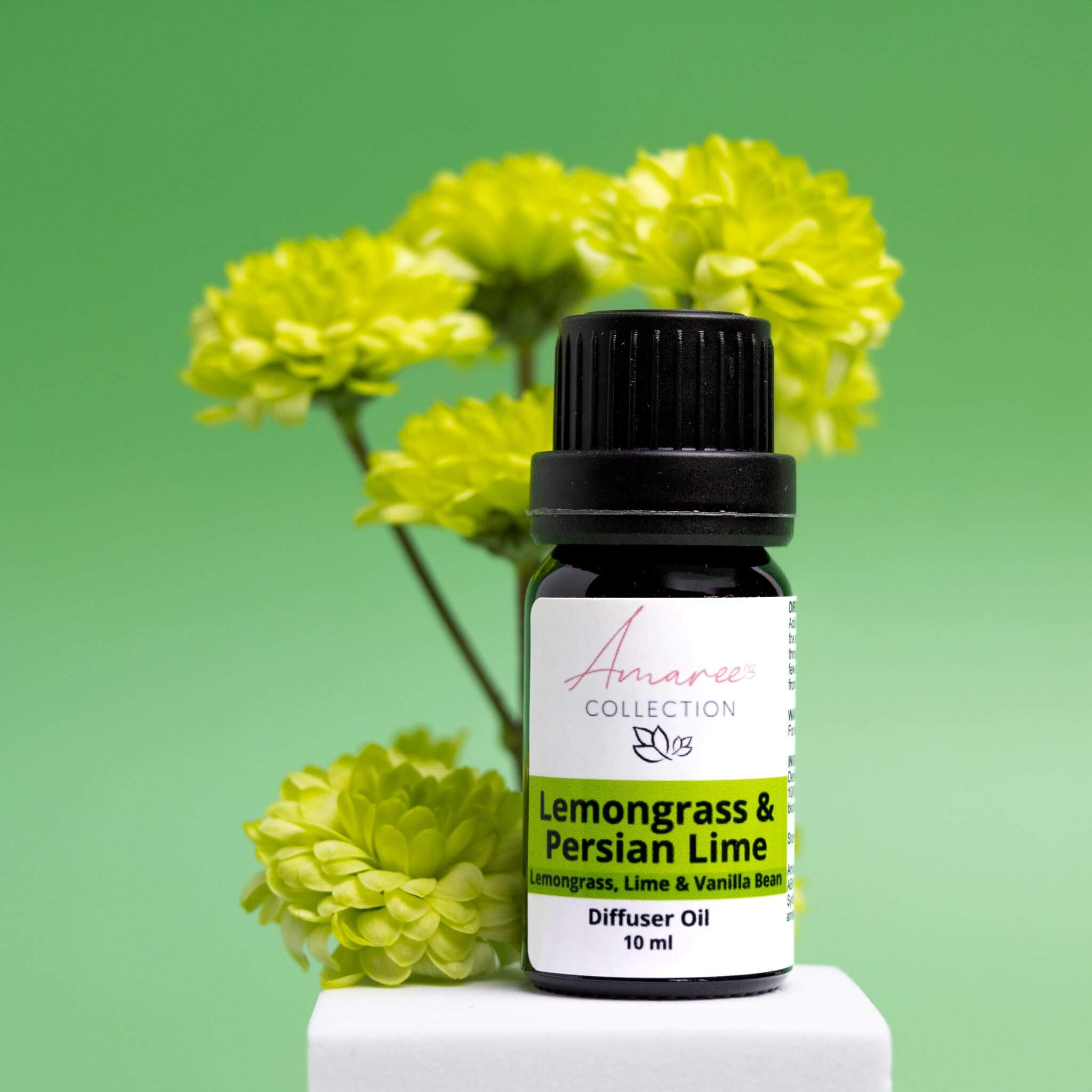 Lemongrass & Persian Lime Diffuser Oil bottle with floral background, energizing scent for freshness in spaces.