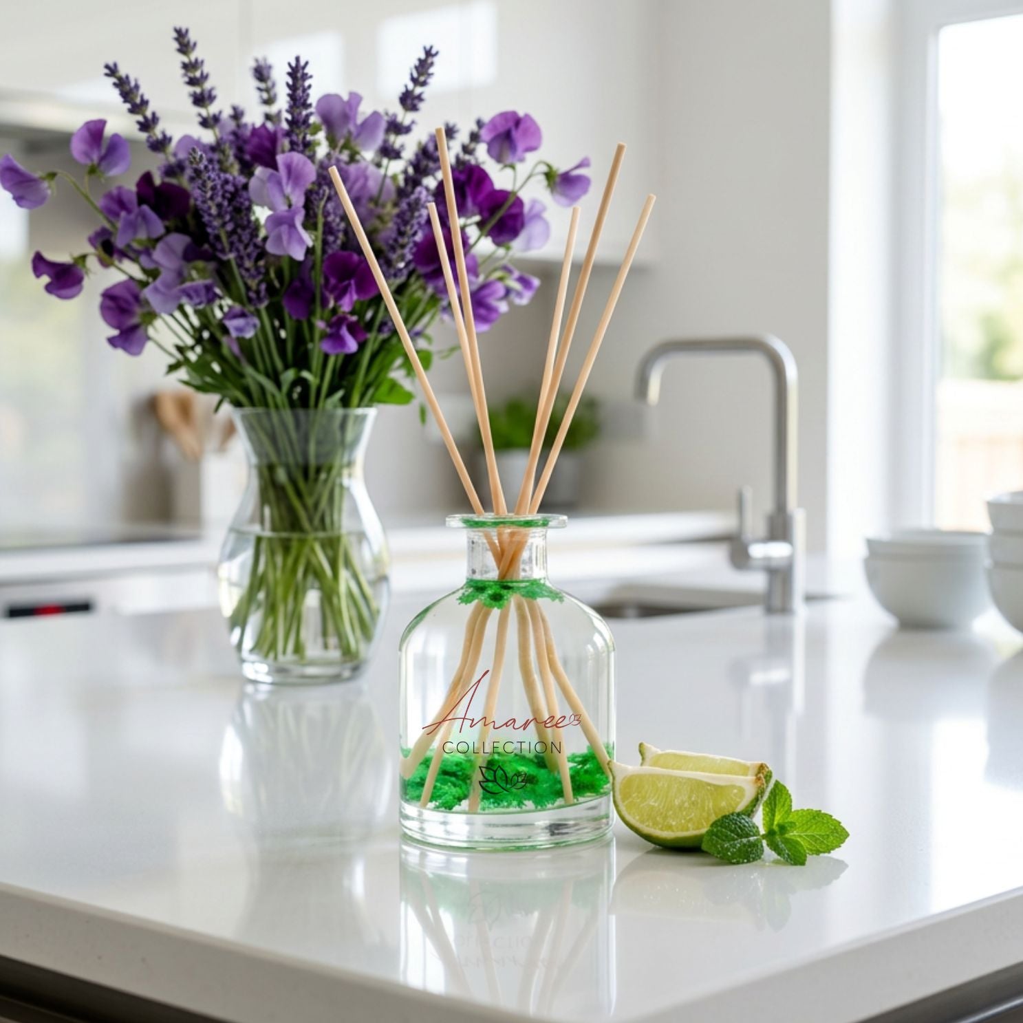 A diffuser bottle with reeds, a vase of purple flowers, and a lime wedge on a kitchen counter.