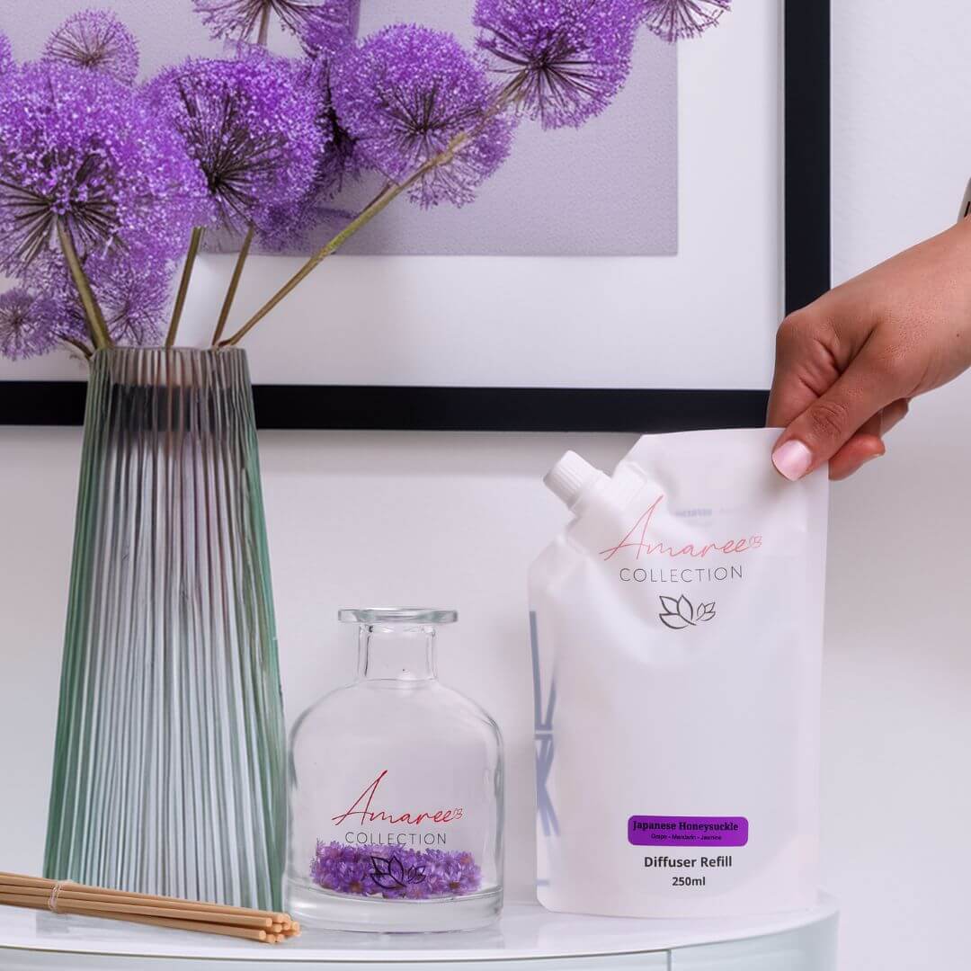 Japanese Honeysuckle Reed Diffuser Refill 250ml in elegant setting with purple floral accents.