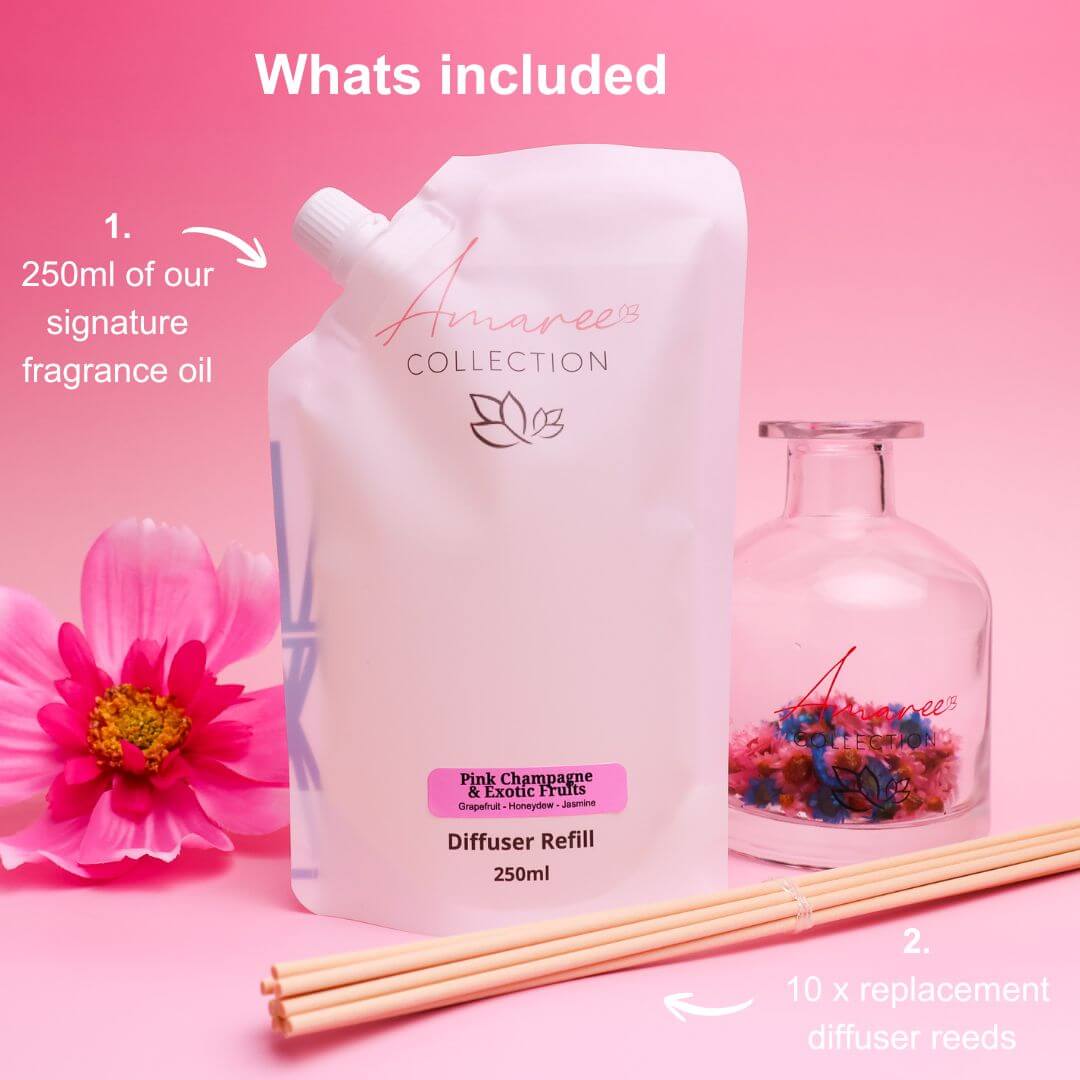 Pink Champagne & Exotic Fruits Reed Diffuser Refill 250ml packaging with diffusers and flowers on a pink background.