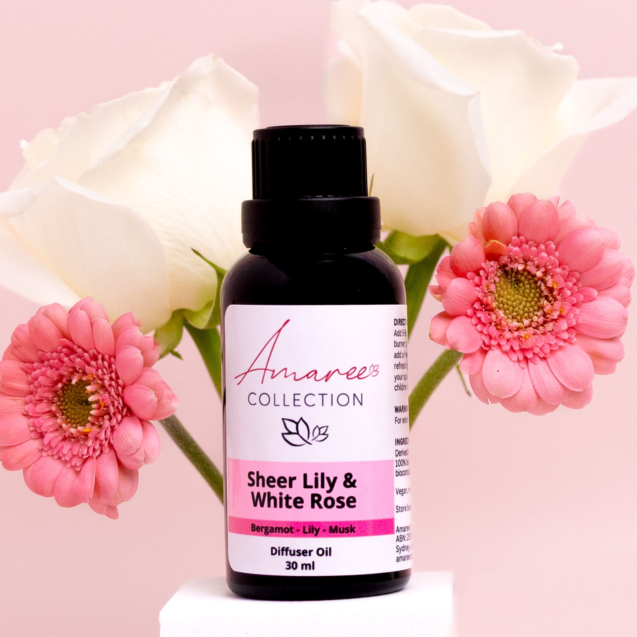 Amaree Collection diffuser oil bottle with pink flowers on a pink background