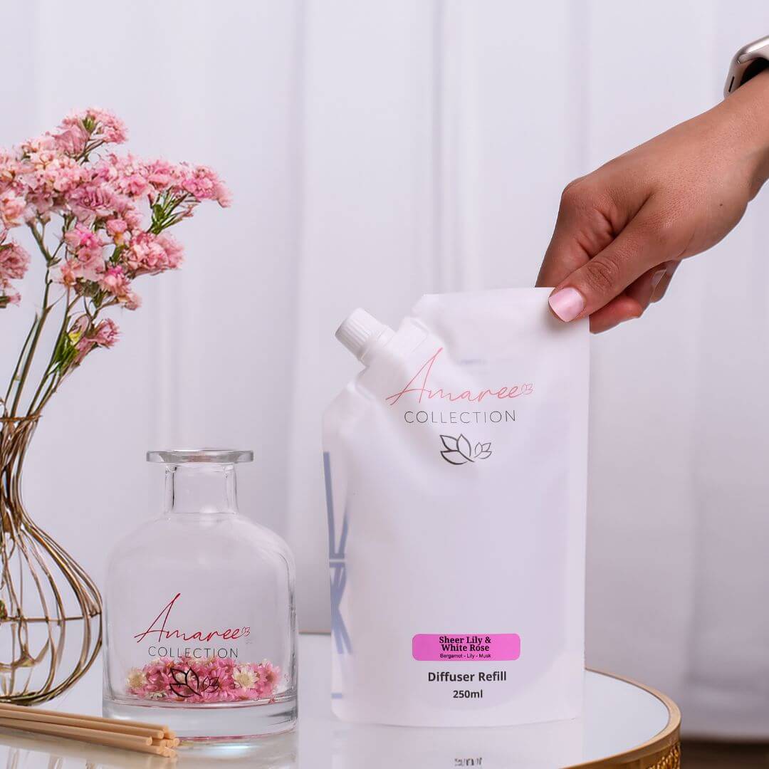 Sheer Lily & White Rose Reed Diffuser Refill 250ml packaging with flowers on a table.
