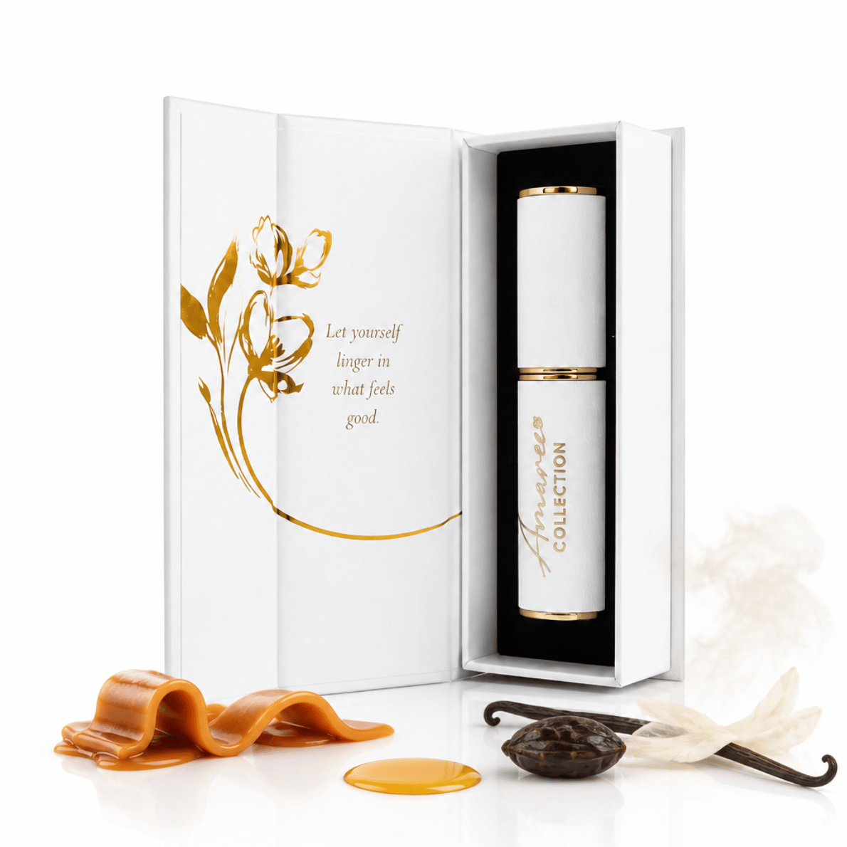 A white and gold cosmetic gift set from Amaree Collection, featuring an open white box with gold floral artwork and a white cylindrical bottle with gold trim inside. Decorative caramel, vanilla bean, and cream petals are arranged around the box on a clean white background.