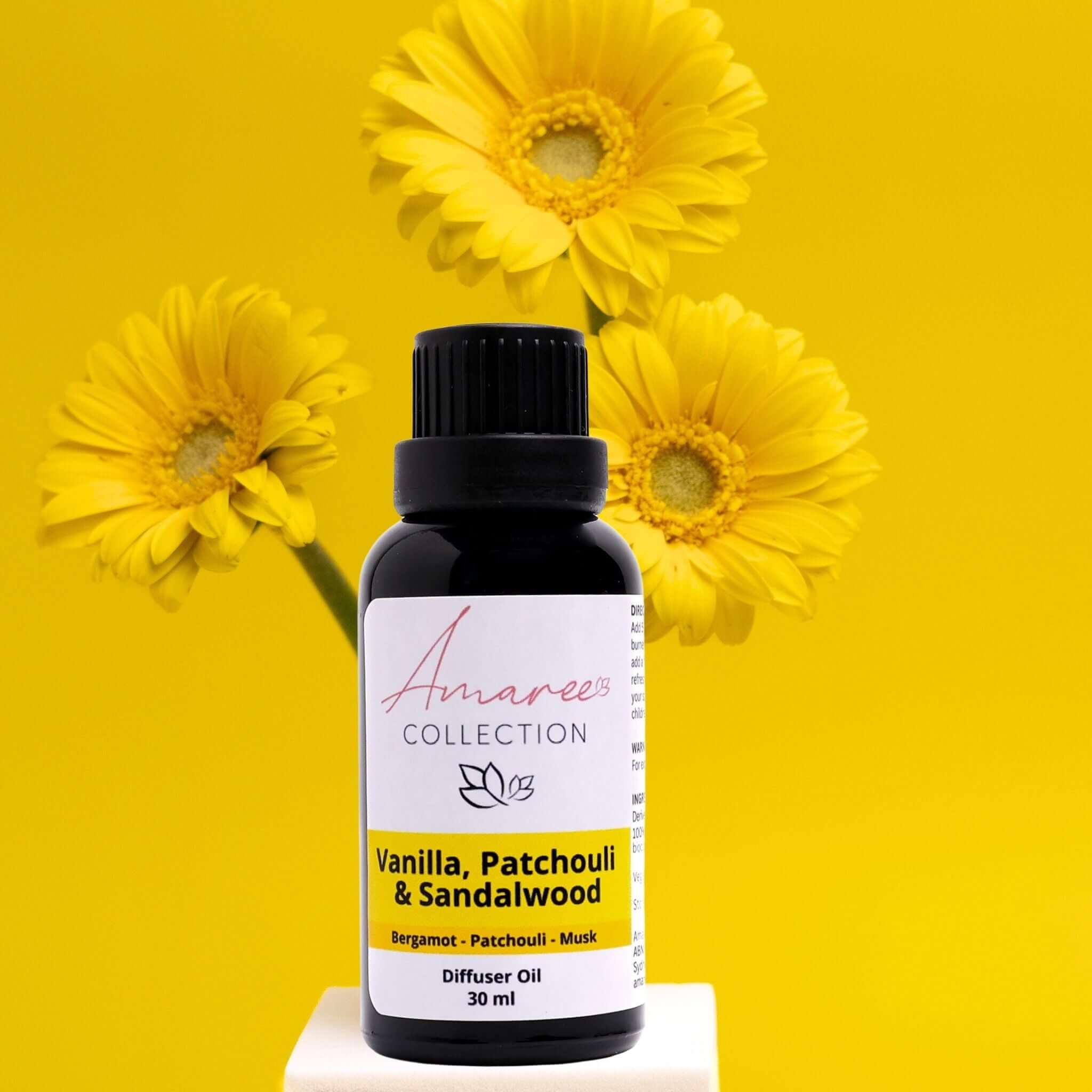 Vanilla Patchouli & Sandalwood Diffuser Oil bottle with yellow daisies background