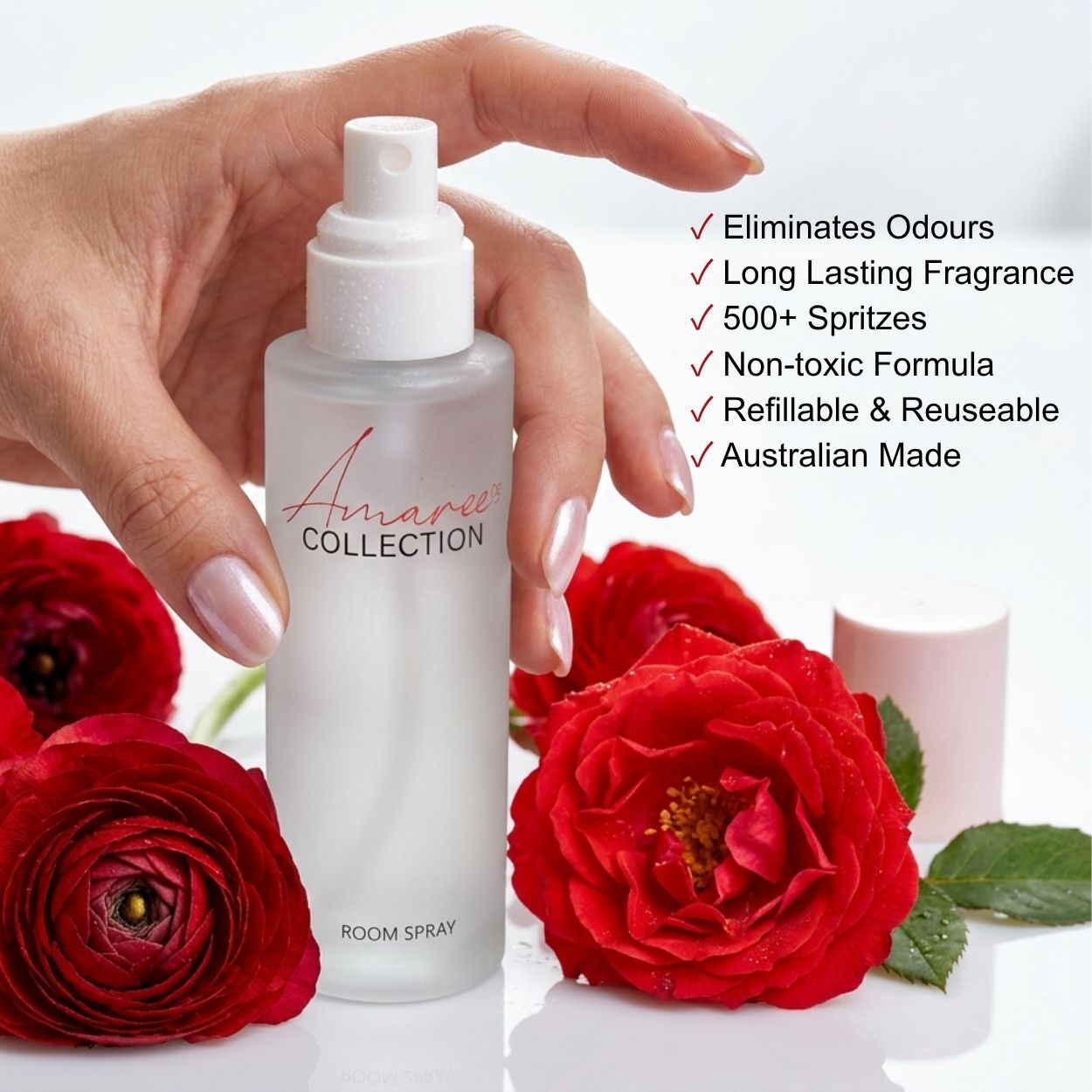 A hand holds a frosted glass room spray bottle labeled &