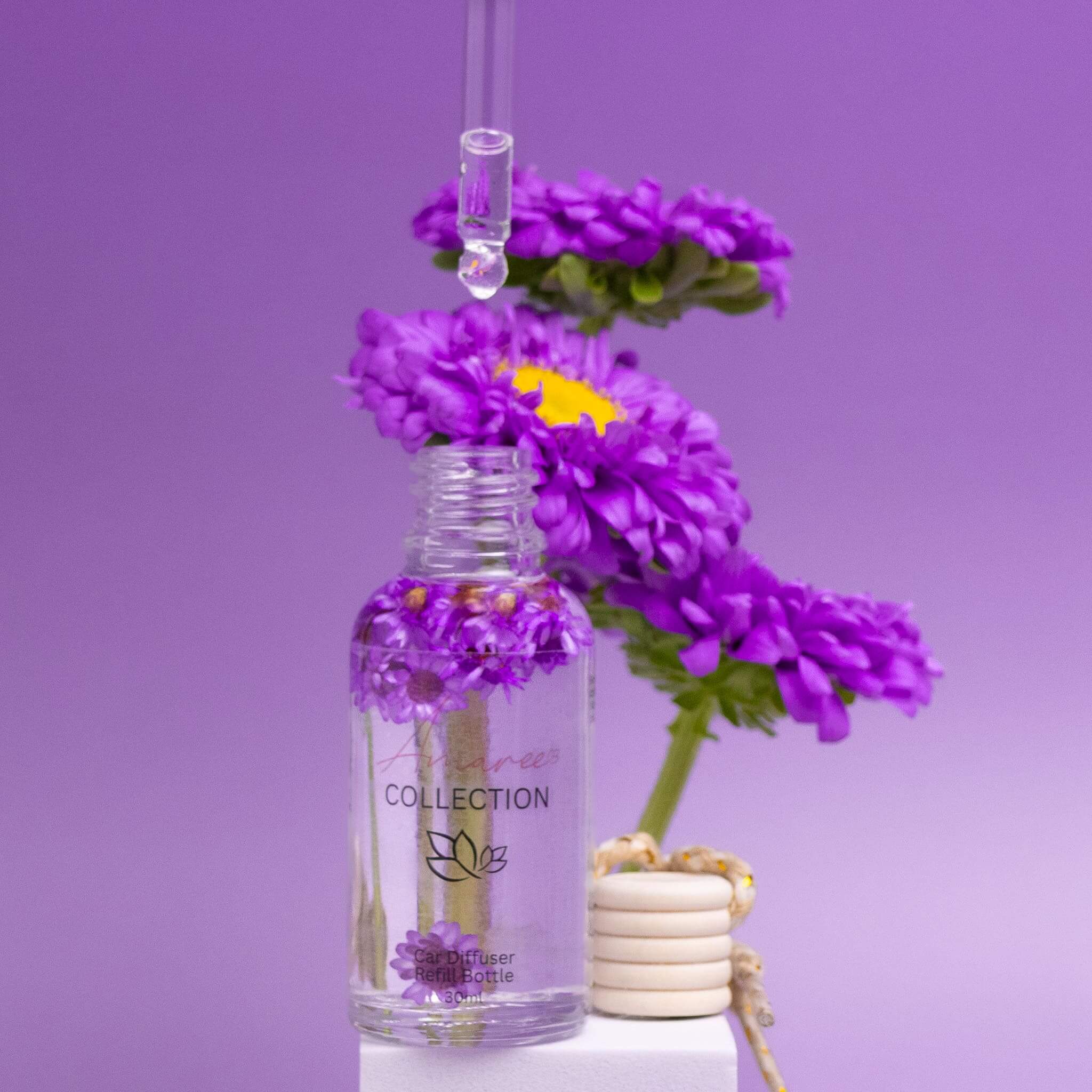 Japanese Honeysuckle Car Diffuser Refill glass bottle with purple floral fragrance oil and eco-friendly refills on purple background