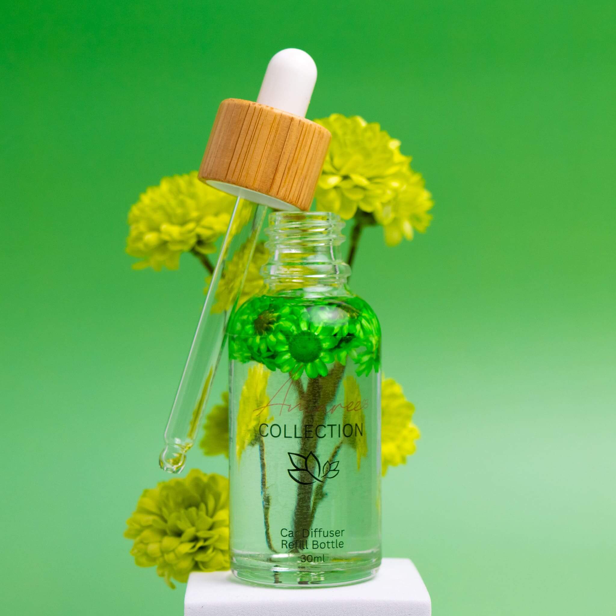 Coconut Lime Car Diffuser Refill in a clear bottle with a bamboo lid and dropper, set against a vibrant green background.