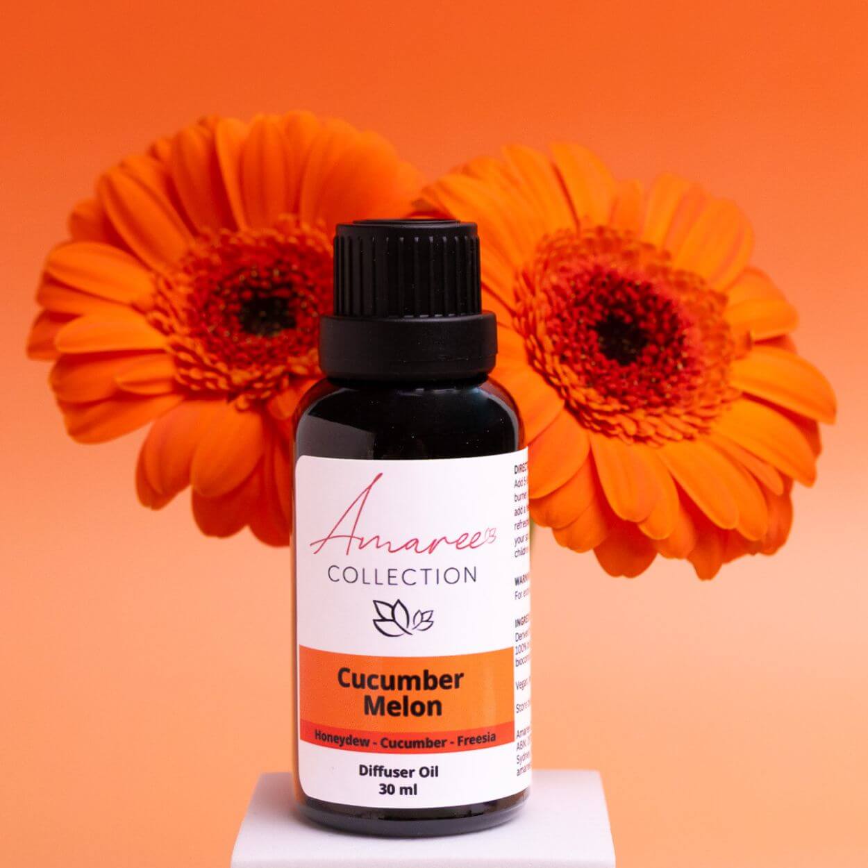 Cucumber Melon Diffuser Oil bottle surrounded by vibrant orange flowers, 30 ml size.