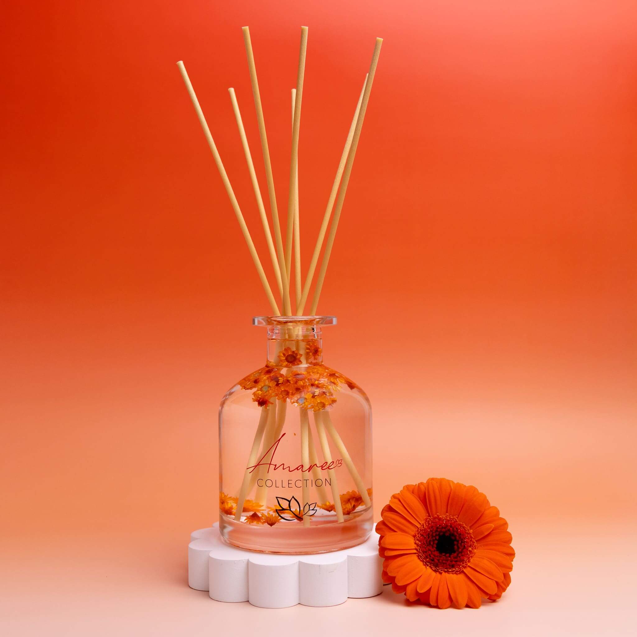 Cucumber Melon Reed Diffuser 250ml displayed with orange background and flower accents.
