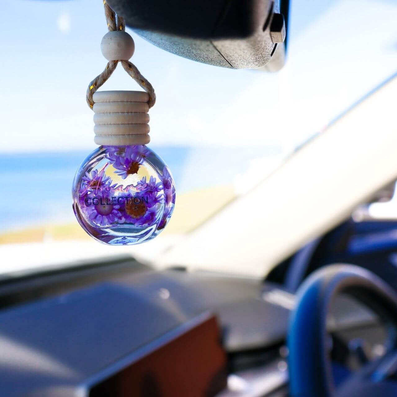 Black Amber & Lavender Car Diffuser hanging in car interior with calming floral woody scent by the ocean