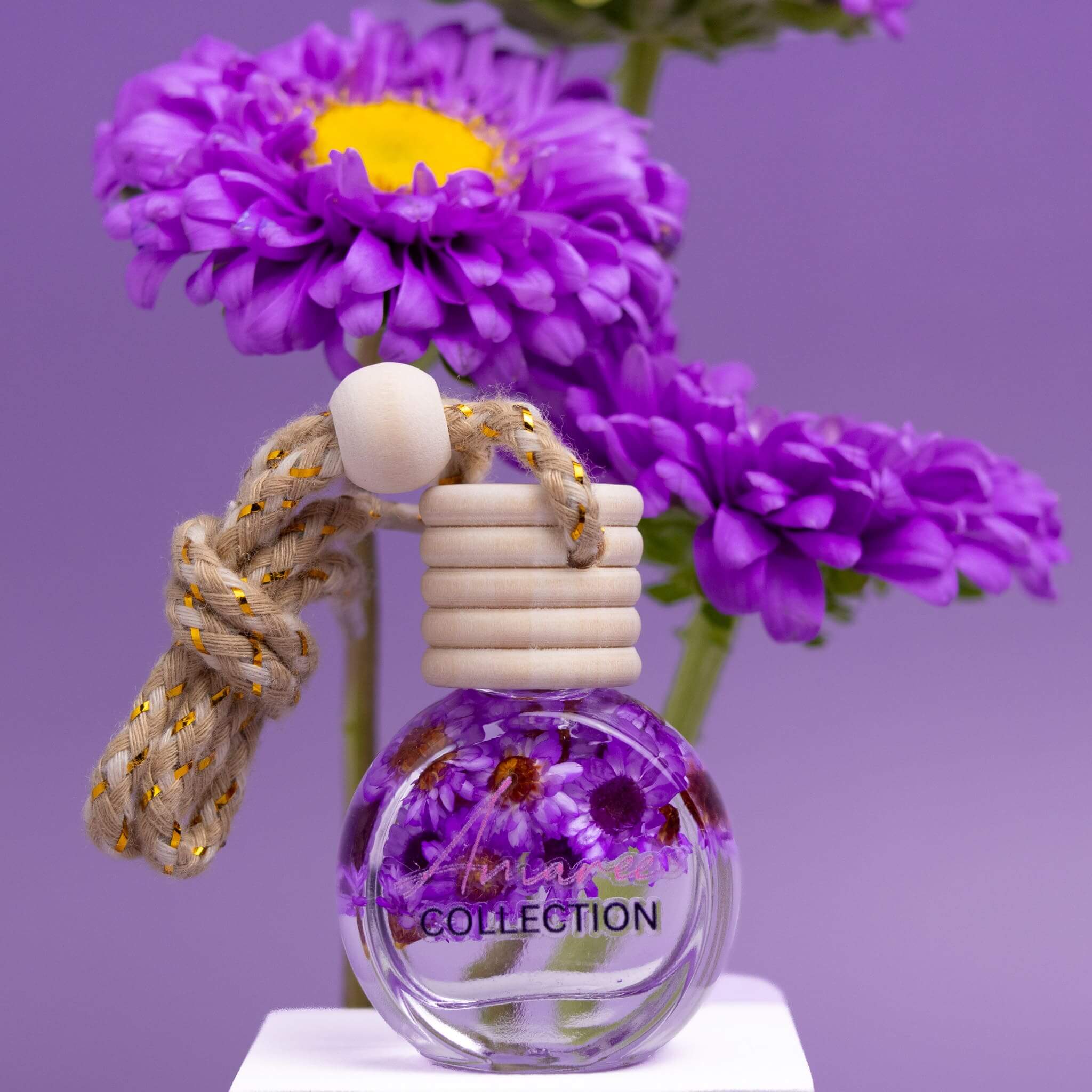 Japanese Honeysuckle Car Diffuser with purple floral design and wooden cap against violet flower background