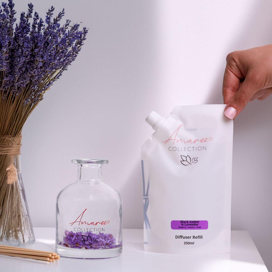 Black Amber & Lavender Reed Diffuser Refill 250ml with lavender flowers in a glass jar and pouch packaging.