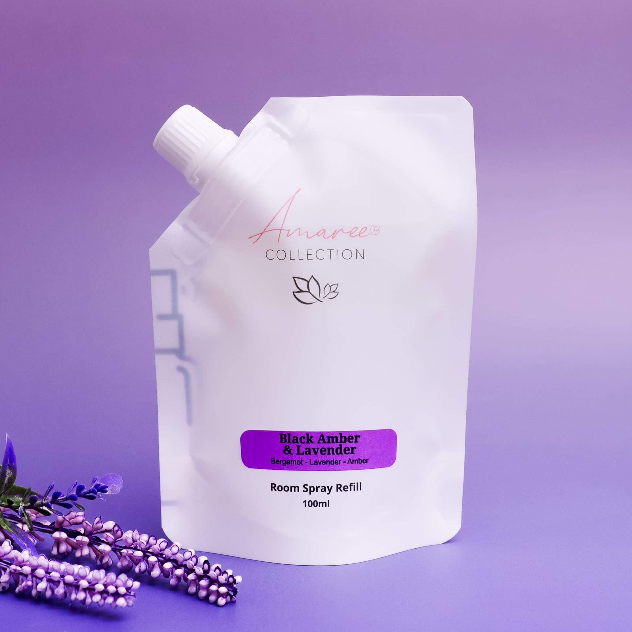 Black Amber & Lavender Room Spray Refill 100ml in a stylish pouch with lavender flowers.