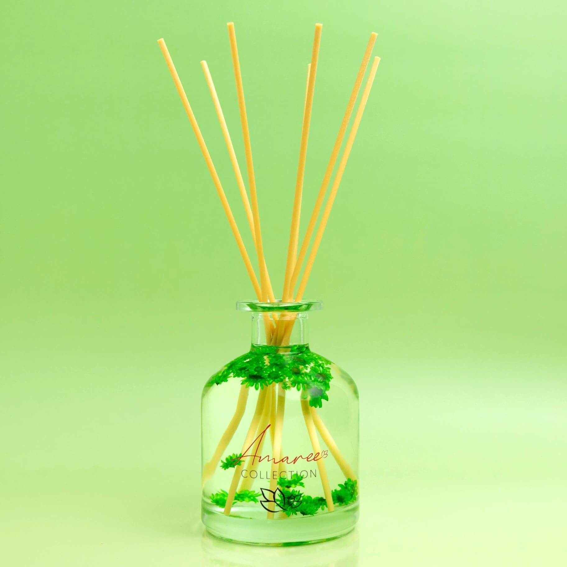 Lemongrass & Persian Lime Reed Diffuser 250ml in a glass bottle with natural reeds, vibrant green background.