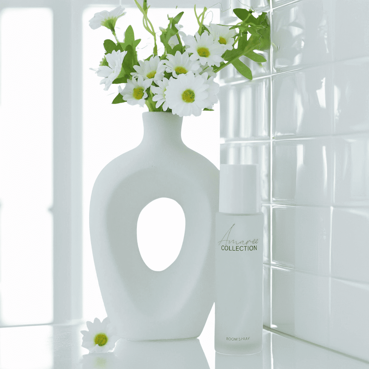 Lemongrass & Persian Lime Room Spray 100ml next to a modern vase with daisies on a stylish countertop.