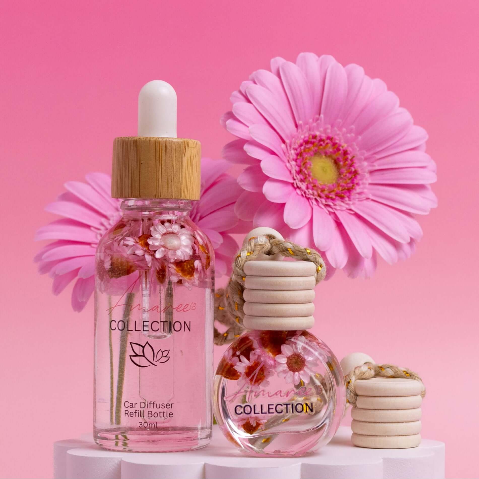 Lychee Peony Car Diffuser Kit featuring elegant refill bottles and pink flowers, showcasing a fresh, fruity fragrance.