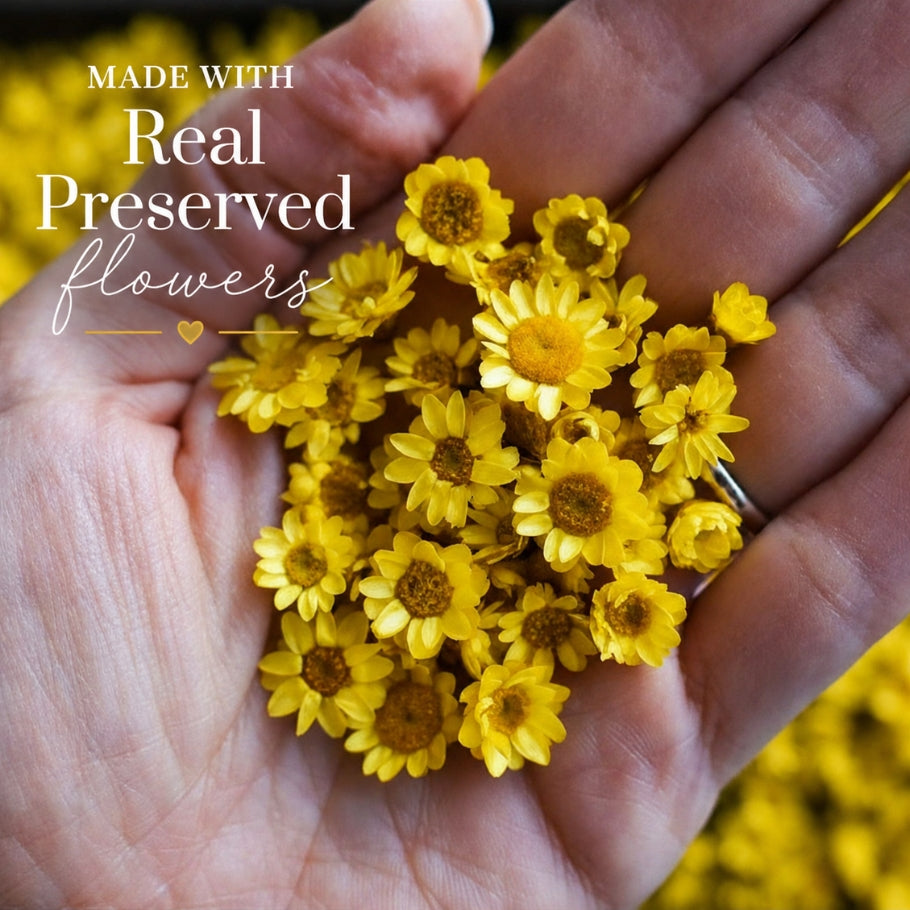 Hand holding yellow preserved flowers with text &