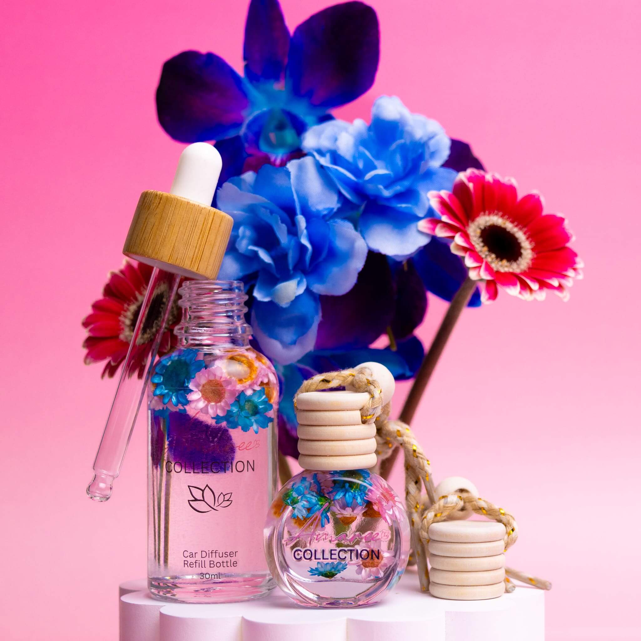 Pink Champagne & Exotic Fruits Car Diffuser Kit with floral decor and refill bottle on a colorful background.