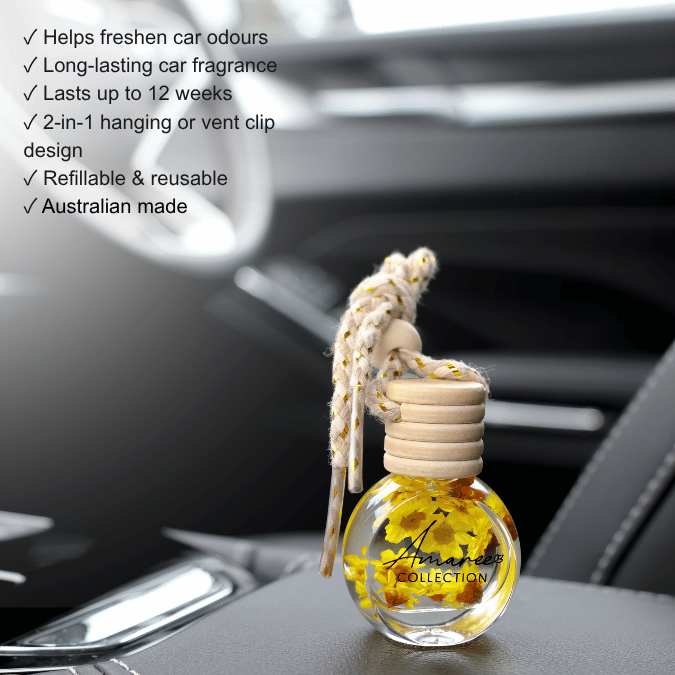 A clear glass car fragrance bottle with a beige woven hanging cord and a light wood cap, shown resting on a car dashboard with a blurred interior background. White text on the left lists product benefits such as helping freshen car odours and lasting up to 12 weeks.