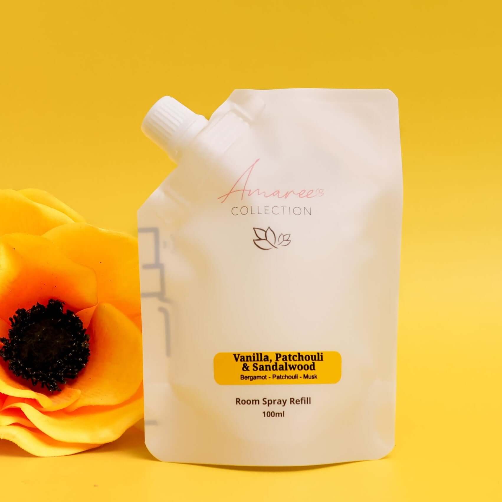 Vanilla Patchouli & Sandalwood Room Spray Refill 100ml in pouch format against a yellow backdrop.