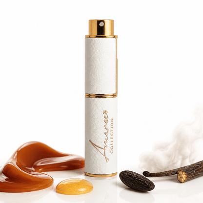A white cylindrical perfume atomizer spray bottle with gold trim and a gold cap, standing upright on a white surface. The bottle is branded &