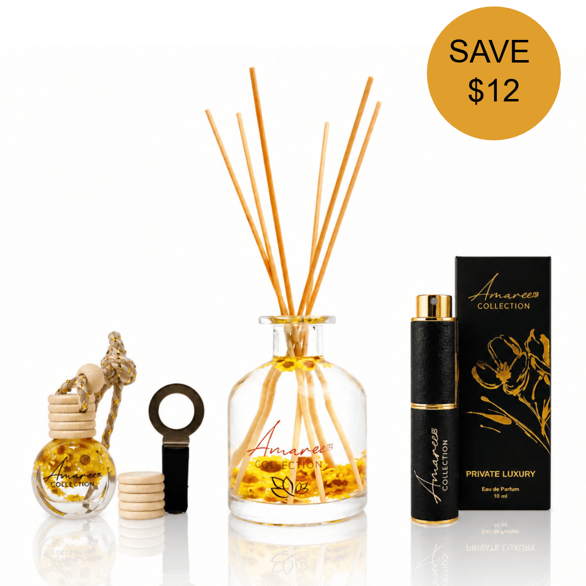 A reed diffuser set with a clear glass bottle, natural wood reeds, a small glass bottle with a cork stopper, a black cylindrical diffuser atomizer, and a black branded box. A gold circle in the top right says SAVE $12.