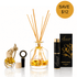 A reed diffuser set with a clear glass bottle, natural wood reeds, a small glass bottle with a cork stopper, a black cylindrical diffuser atomizer, and a black branded box. A gold circle in the top right says SAVE $12.