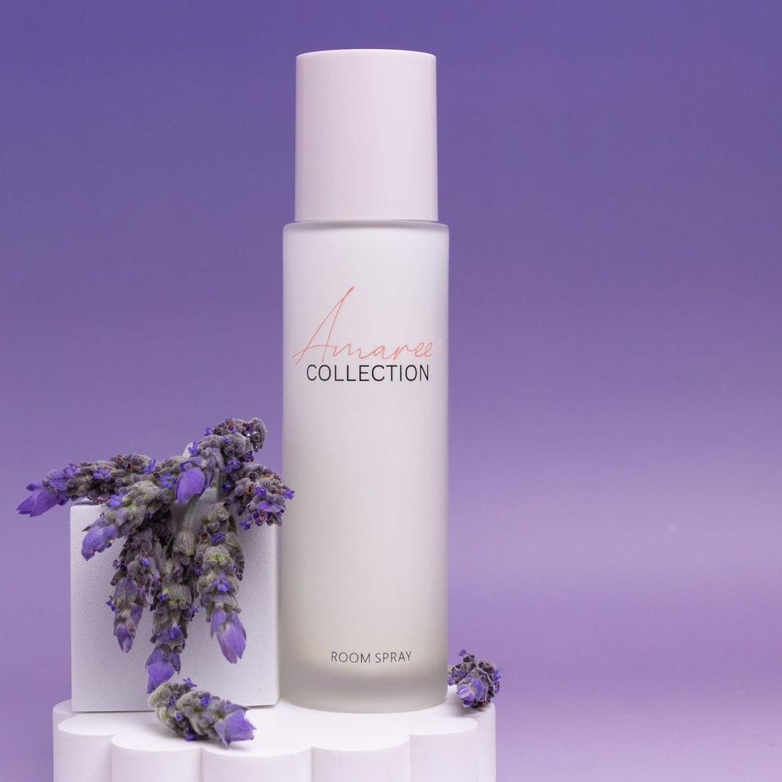 Black Amber &amp; Lavender Room Spray 100ml with lavender flowers on a purple background.