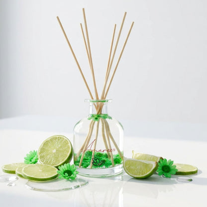 Reed diffuser with lime slices and flowers on a white background
