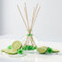 Reed diffuser with lime slices and flowers on a white background
