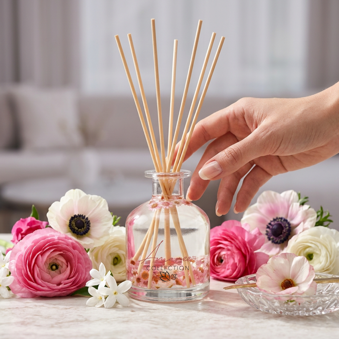 Hand holding a diffuser with floral arrangement on a table