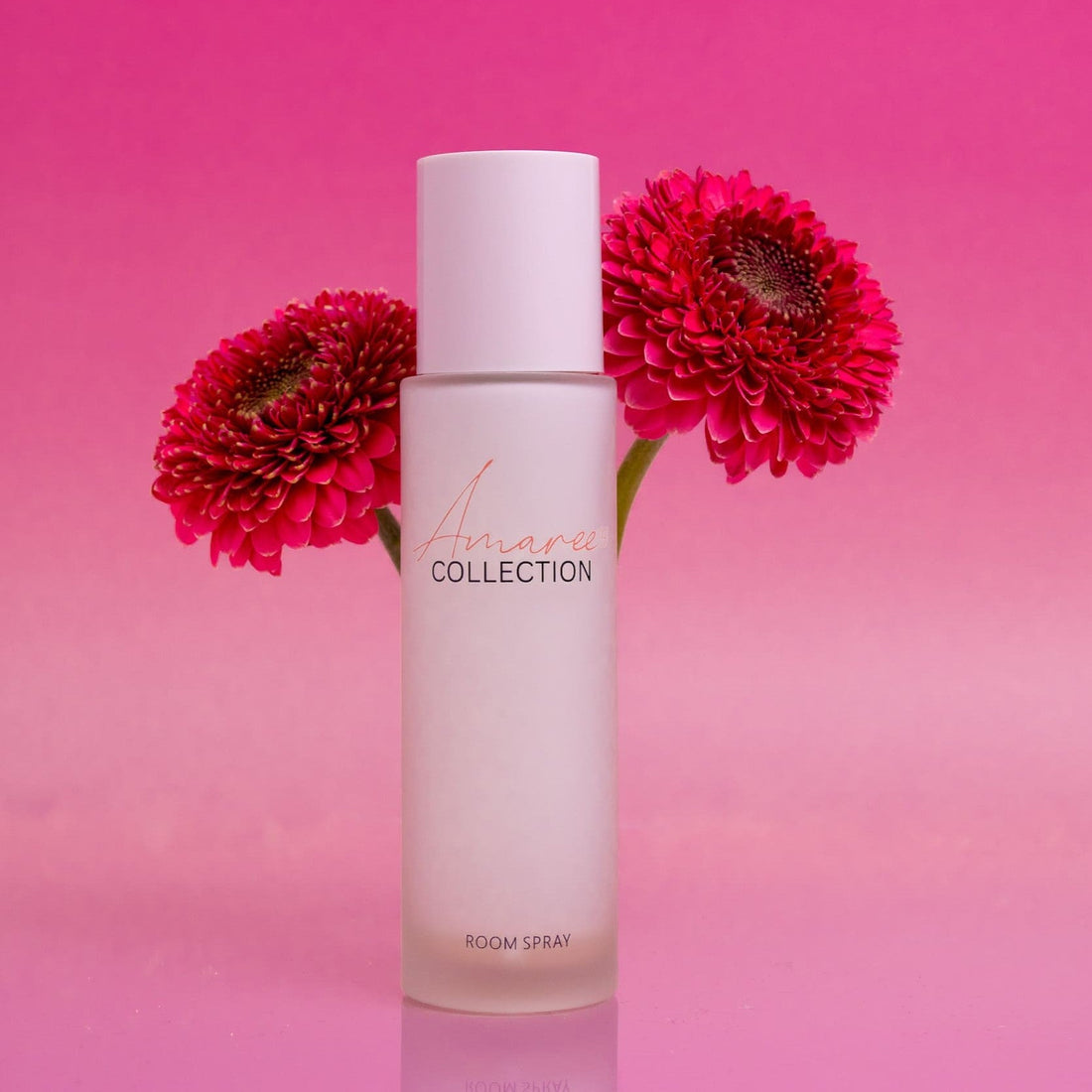 Lychee Guava Room Spray 100ml in a frosted bottle with pink flowers on a vibrant pink background.