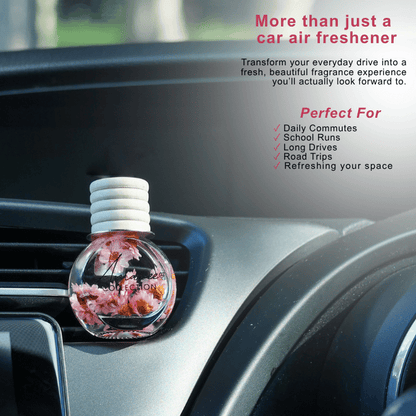 A round car air freshener bottle with a white ribbed cap, filled with pink and orange floral liquid, resting on a car dashboard. The image includes promotional text highlighting its use for daily commutes, school runs, and road trips.