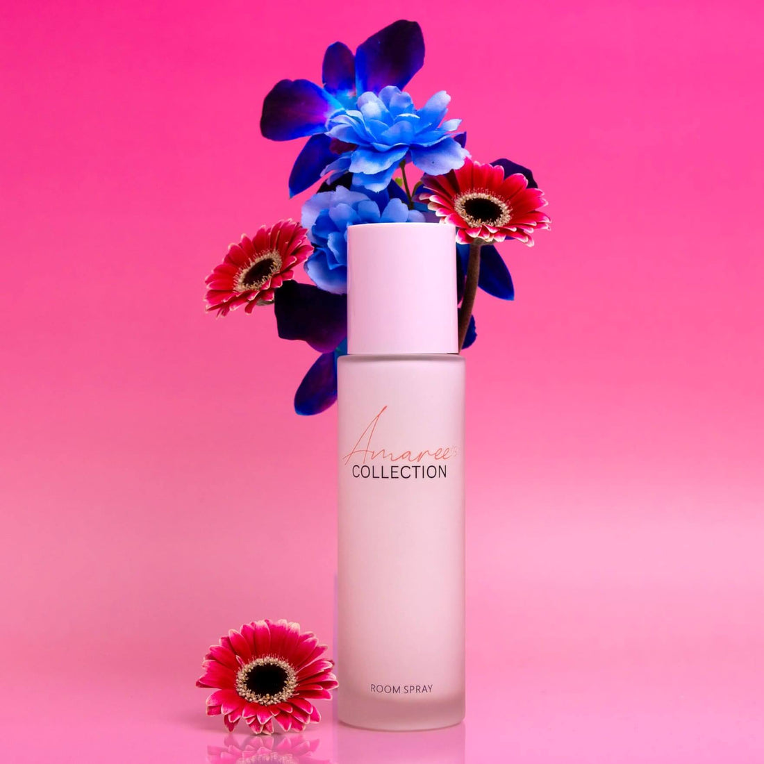 Pink Champagne &amp; Exotic Fruits Room Spray 100ml with vibrant flowers on a pink background.