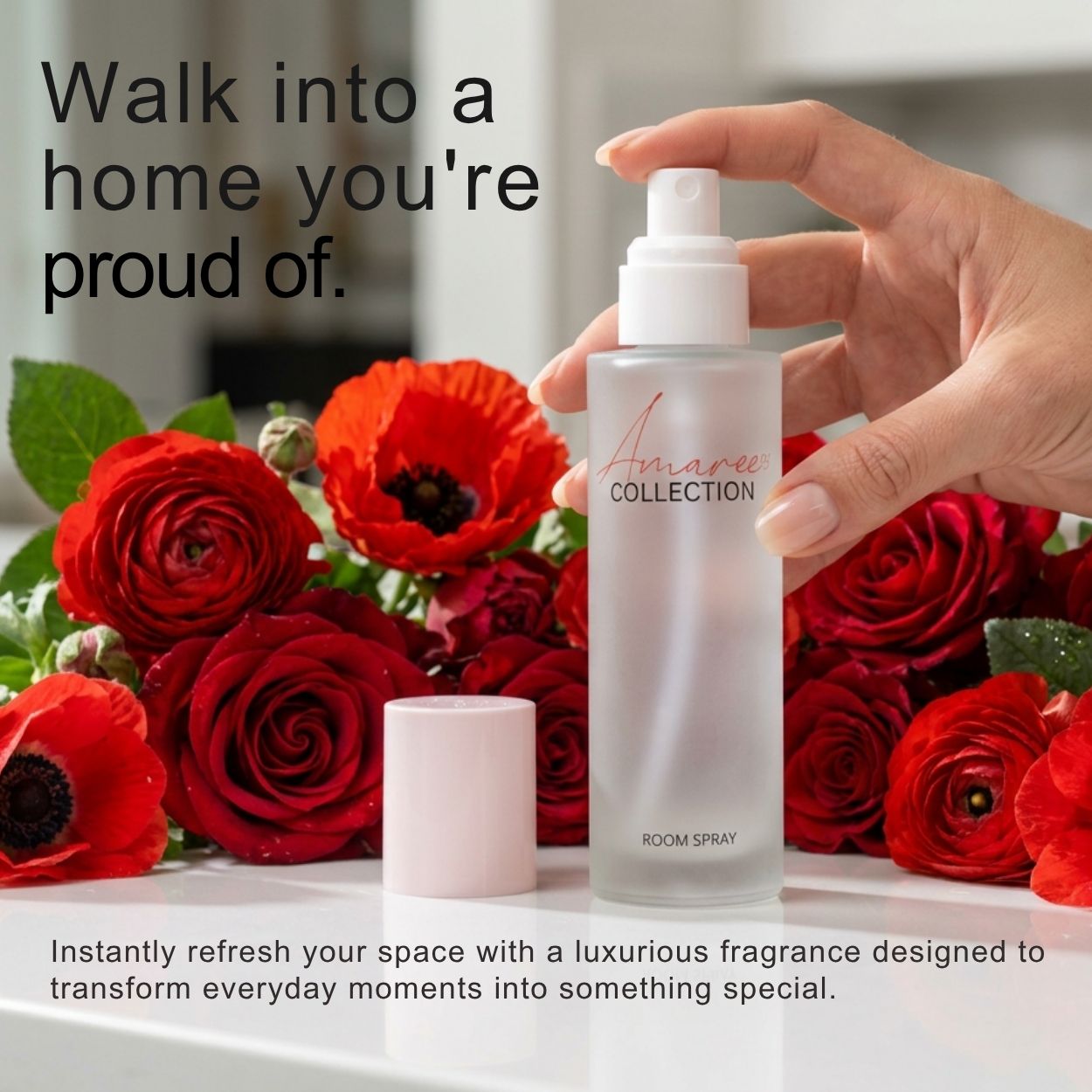 A hand holds a frosted glass room spray bottle labeled &