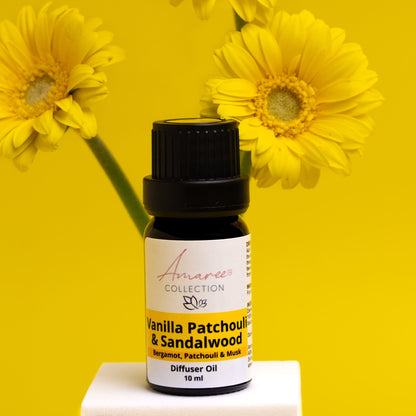 Vanilla Patchouli &amp; Sandalwood diffuser oil bottle with yellow flowers on a yellow background