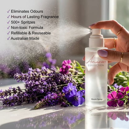 A hand sprays a bottle of room spray, with visible mist coming out. The bottle is labeled &