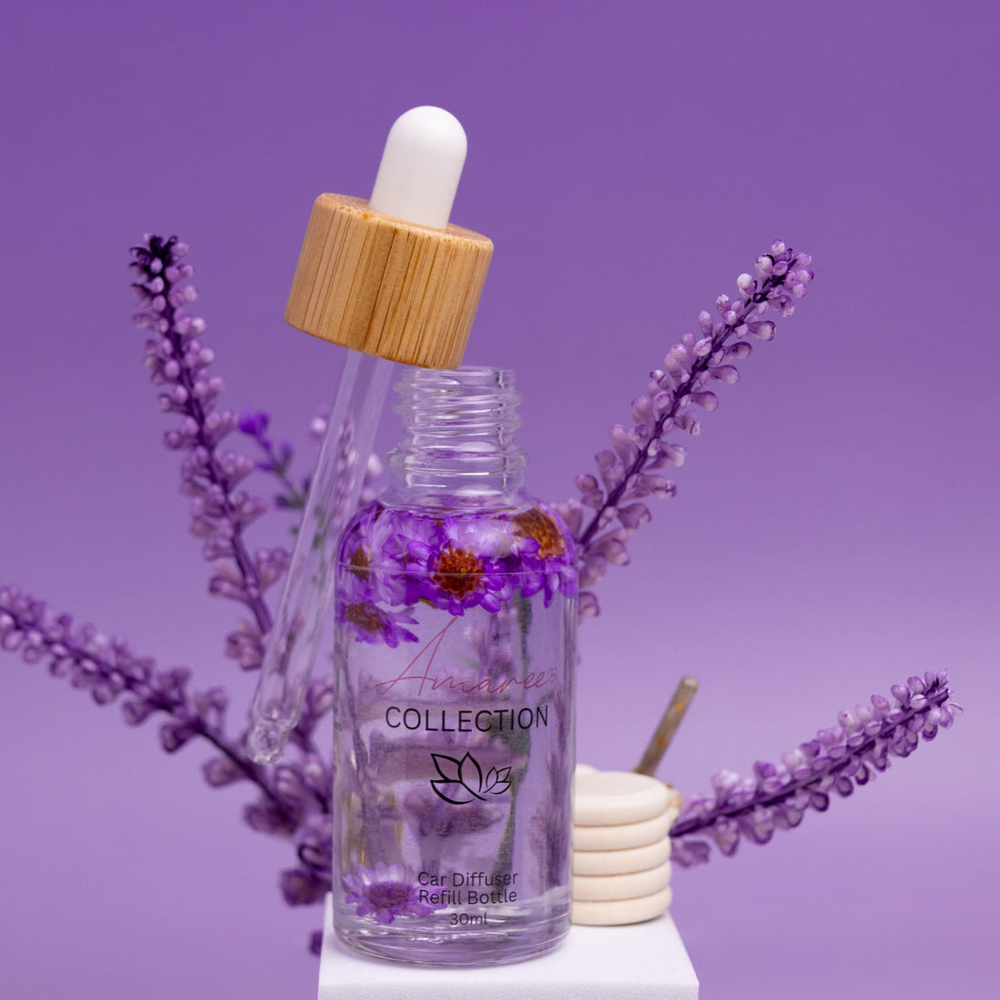 Glass dropper bottle with wooden cap on a purple background with lavender flowers