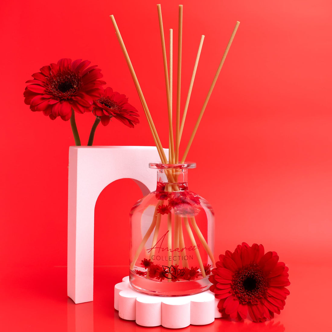 Reed diffuser with floral design on a red background