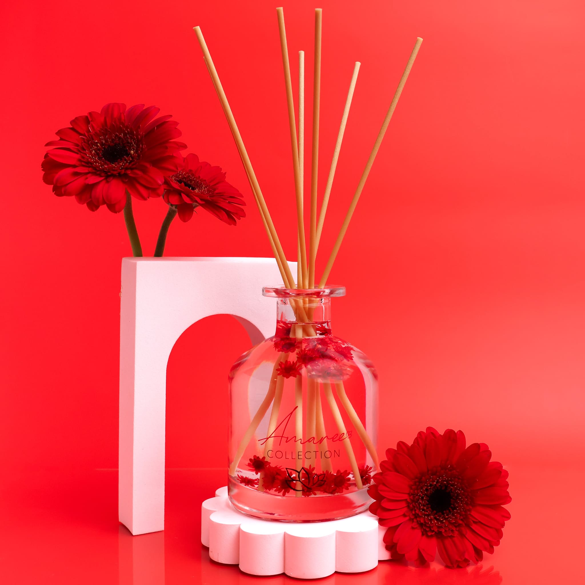 Reed diffuser with floral design on a red background