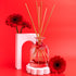 Reed diffuser with floral design on a red background