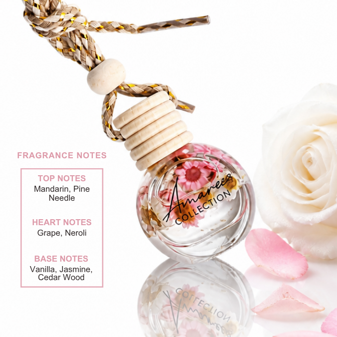 A small round glass fragrance diffuser bottle with dried flowers inside, tied to a braided cord, shown on a white background with a large white rose and pink petals. Text on the left lists fragrance notes from the Amaree Collection.