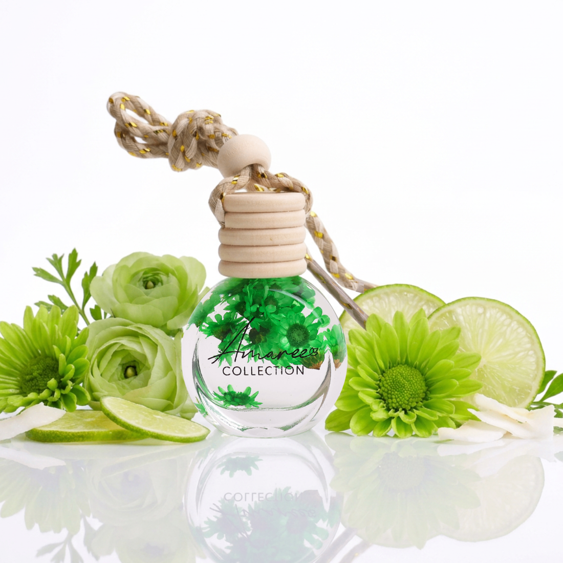 Perfume bottle with green floral design and lime slices on a white background