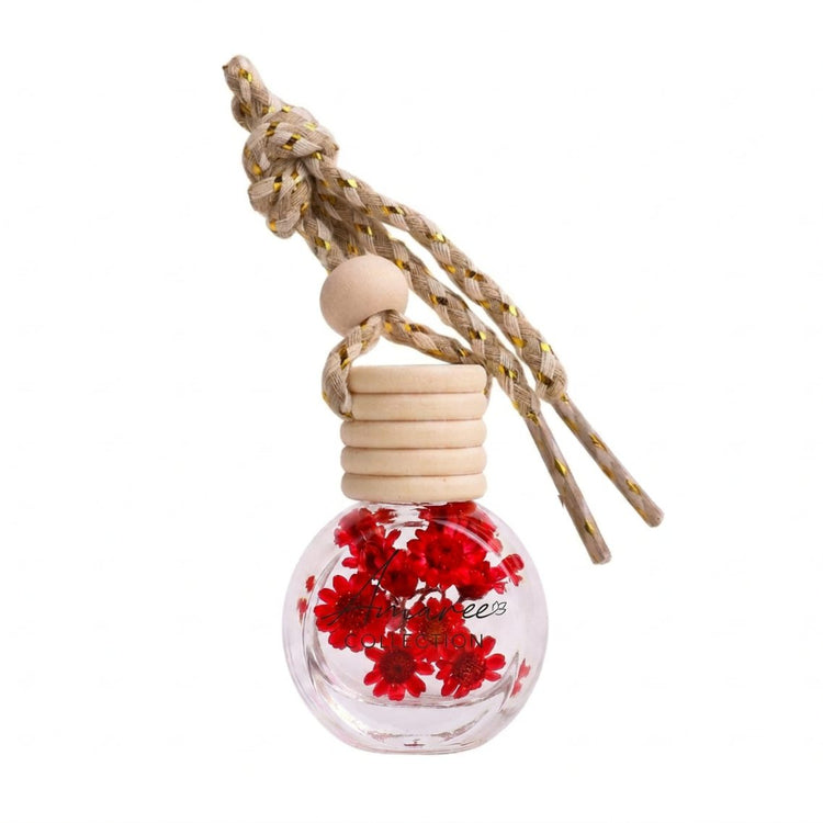 Car air freshener with red flowers inside a clear bottle on a white background