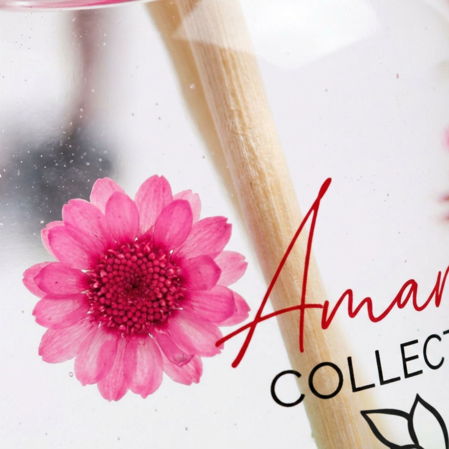 Pink flower with a wooden stick on a white background, featuring the 'Aman' brand.