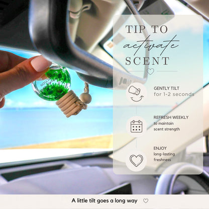 Car air freshener with instructions on how to activate the scent, displayed inside a car.