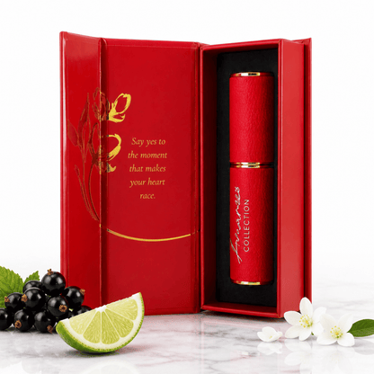 A red cylindrical cosmetic tube with gold lettering stands inside an open matching red gift box. The box interior has gold decorative script and quote text.