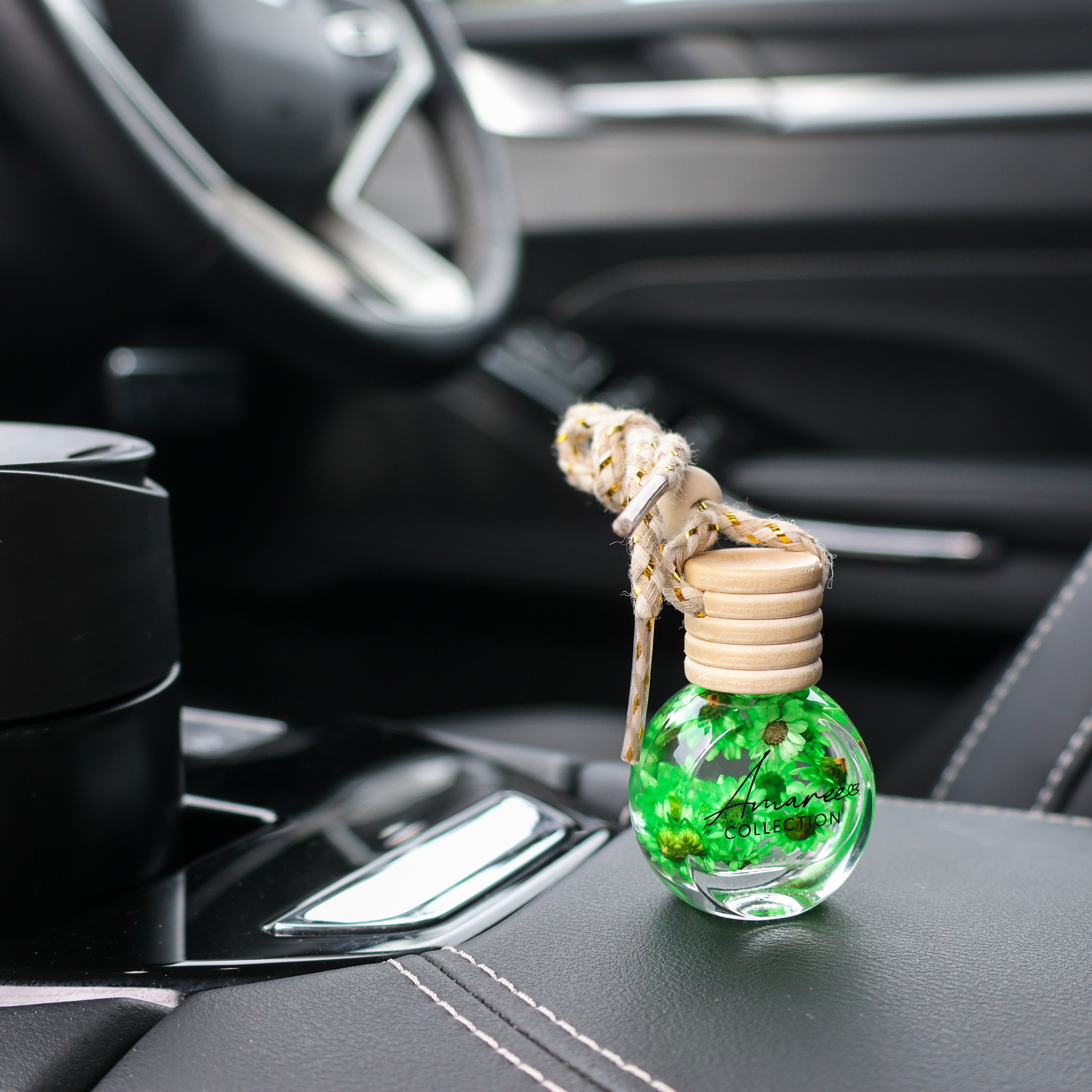 Car air freshener with green decorative elements on a car dashboard