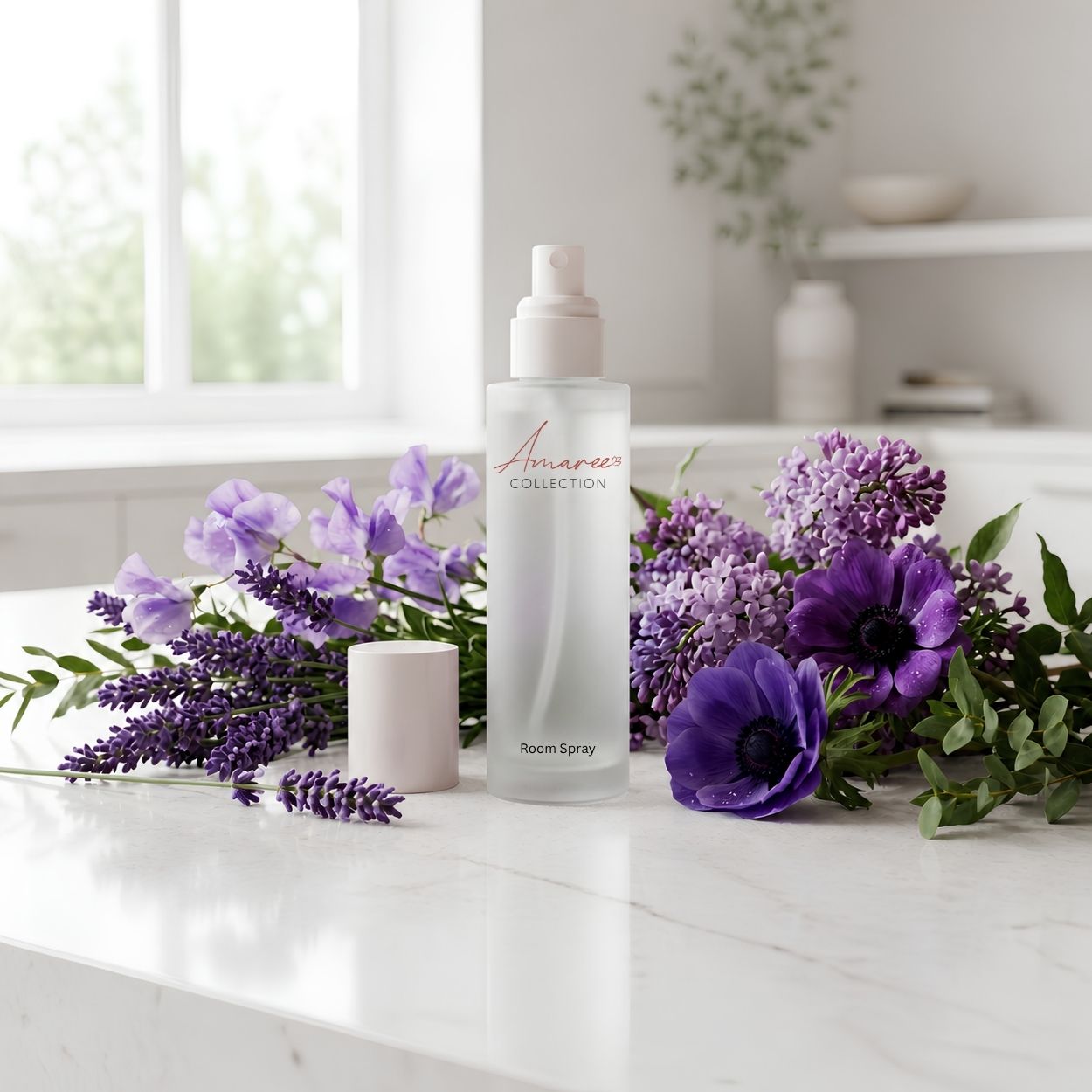 A frosted glass room spray bottle labeled &