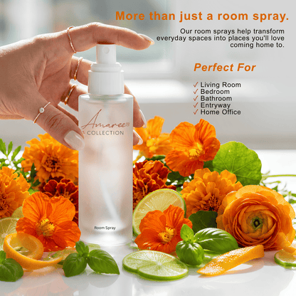 A hand holds a frosted room spray bottle labeled &